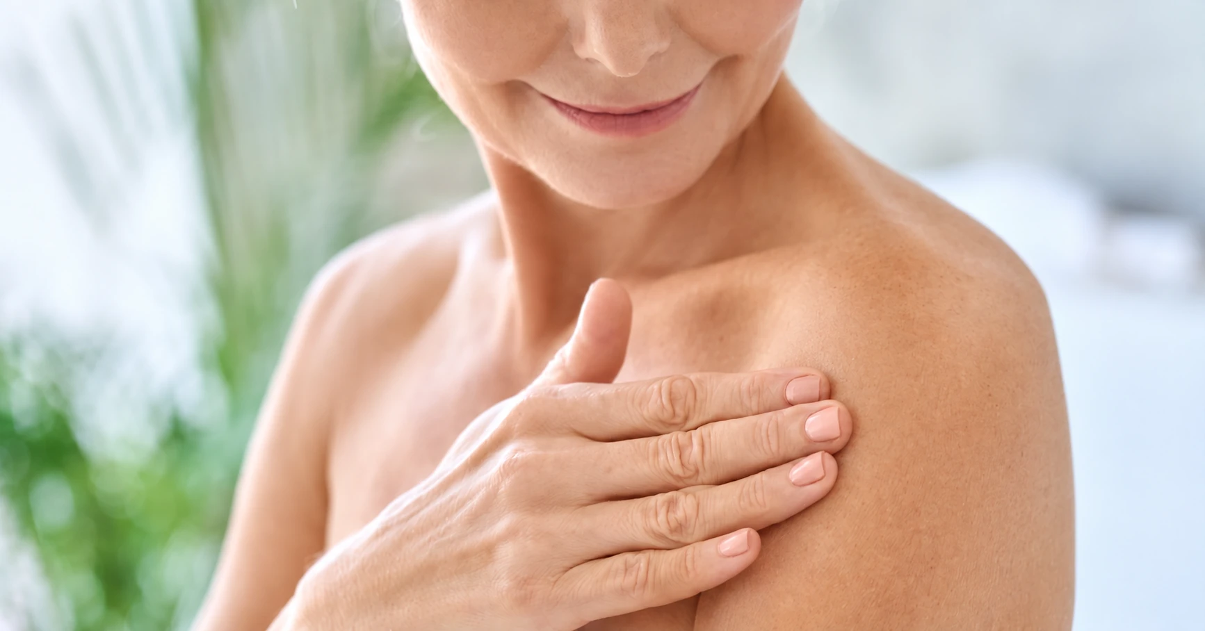 A woman resting her hand on her upper chest.